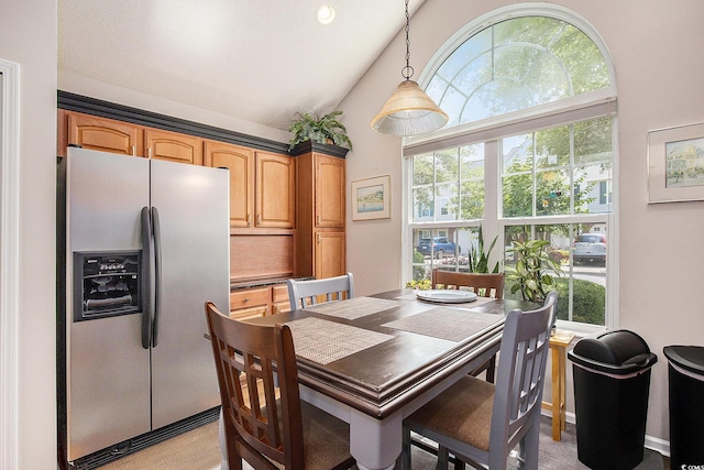 dining space with light carpet and high vaulted ceiling