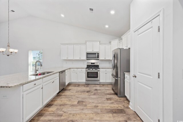 692 Cherry Blossom Dr, Murrells Inlet, SC 29576 - kitchen featuring appliances with stainless steel finishes, a sink, vaulted ceiling, a chandelier, and white cabinetry