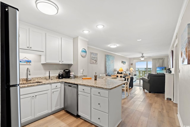 1310 N Waccamaw Dr Unit 204, Garden City Beach, SC 29576 - kitchen featuring stainless steel appliances, a sink, a peninsula, crown molding, and white cabinetry