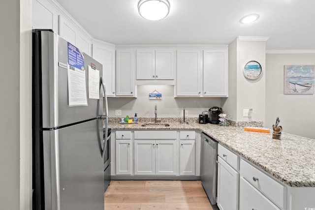 1310 N Waccamaw Dr Unit 204, Garden City Beach, SC 29576 - kitchen with stainless steel appliances, a sink, a peninsula, crown molding, and white cabinets