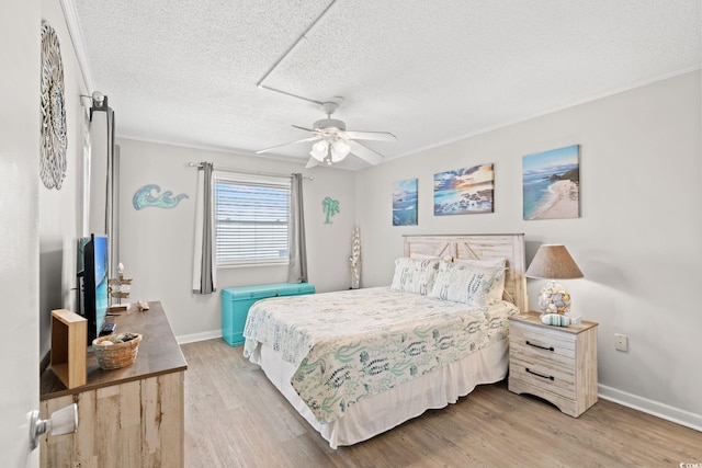 1310 N Waccamaw Dr Unit 204, Garden City Beach, SC 29576 - bedroom featuring light wood-style floors, baseboards, a textured ceiling, and a ceiling fan