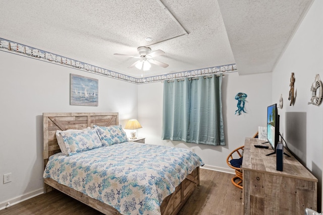 1310 N Waccamaw Dr Unit 204, Garden City Beach, SC 29576 - bedroom with baseboards, dark wood-type flooring, a textured ceiling, and a ceiling fan