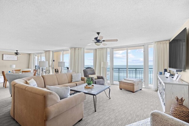 3805 S Ocean Blvd # 503, North Myrtle Beach, SC 29582 - living room with a ceiling fan, floor to ceiling windows, light colored carpet, and a textured ceiling