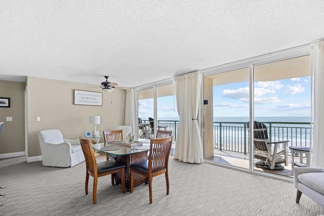 3805 S Ocean Blvd # 503, North Myrtle Beach, SC 29582 - dining room featuring light carpet, expansive windows, a ceiling fan, a textured ceiling, and a water view