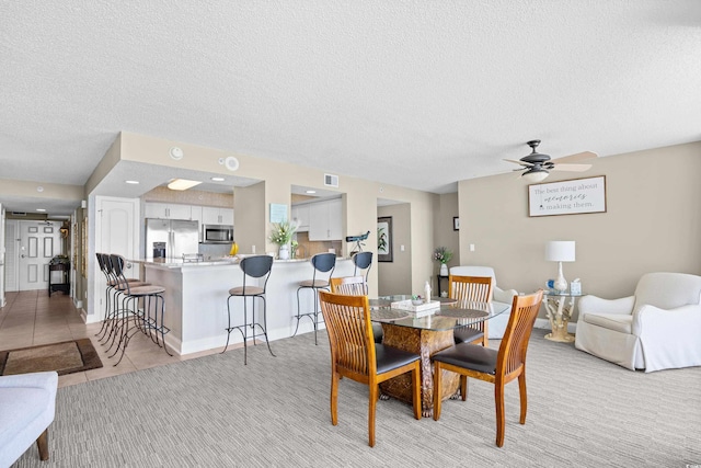 3805 S Ocean Blvd # 503, North Myrtle Beach, SC 29582 - dining space featuring a ceiling fan, a textured ceiling, and light colored carpet