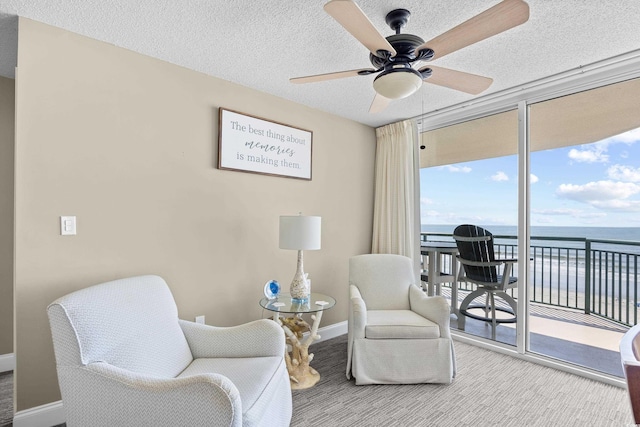 3805 S Ocean Blvd # 503, North Myrtle Beach, SC 29582 - living area with a ceiling fan, carpet floors, baseboards, floor to ceiling windows, and a water view