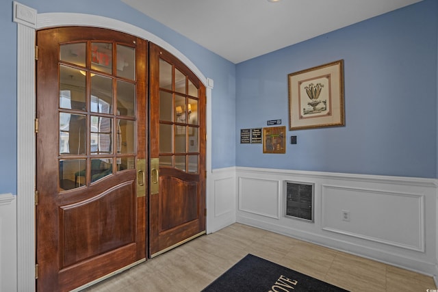 2241 Waterview Dr Unit 537, North Myrtle Beach, SC 29582 - foyer with french doors, a wainscoted wall, tile patterned floors, a decorative wall, and arched walkways
