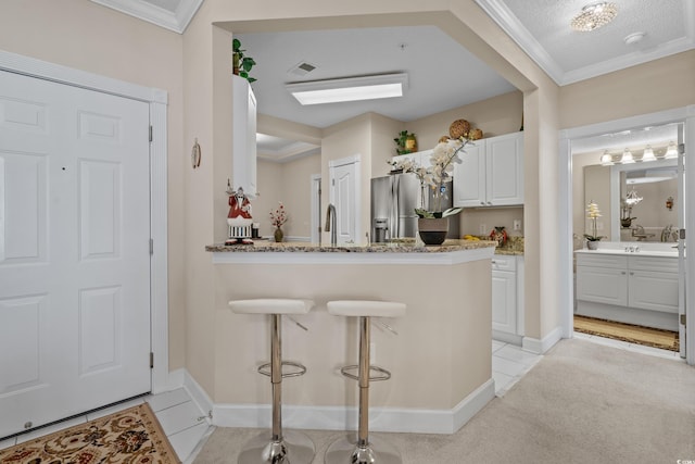 2241 Waterview Dr Unit 537, North Myrtle Beach, SC 29582 - kitchen featuring white cabinetry, light stone countertops, stainless steel refrigerator with ice dispenser, light colored carpet, and a kitchen breakfast bar