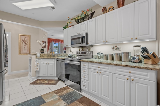2241 Waterview Dr Unit 537, North Myrtle Beach, SC 29582 - kitchen with stainless steel appliances, white cabinets, light stone countertops, and light tile patterned flooring