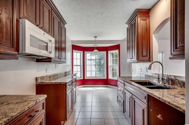 638 Hatteras River Rd, Myrtle Beach, SC 29588 - kitchen featuring white microwave, a sink, light stone countertops, pendant lighting, and a textured ceiling