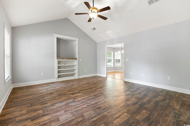 empty room featuring ceiling fan, vaulted ceiling, dark wood-style floors, a chandelier, and built in features