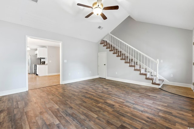 unfurnished living room featuring a ceiling fan, stairs, wood finished floors, lofted ceiling, and baseboards