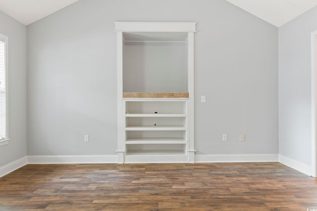 unfurnished bedroom with vaulted ceiling, wood finished floors, multiple windows, and baseboards