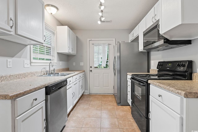 kitchen featuring black / electric stove, stainless steel dishwasher, a sink, track lighting, and healthy amount of natural light