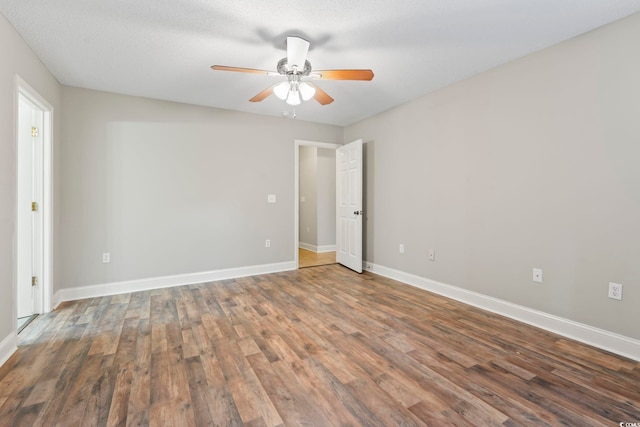 empty room featuring wood finished floors, ceiling fan, and baseboards