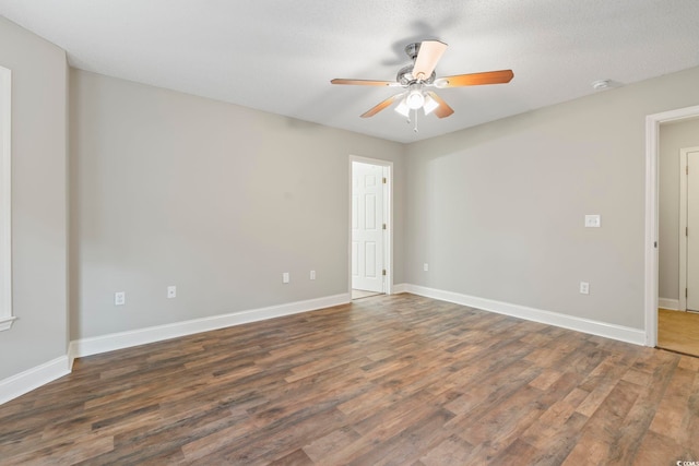 unfurnished room featuring ceiling fan, wood finished floors, baseboards, and a smoke detector