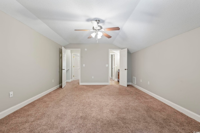 unfurnished bedroom featuring vaulted ceiling, light carpet, baseboards, and ceiling fan