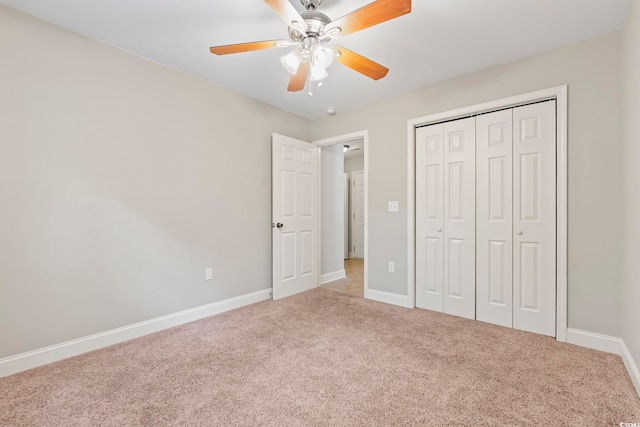 unfurnished bedroom featuring carpet floors, baseboards, a closet, and a ceiling fan