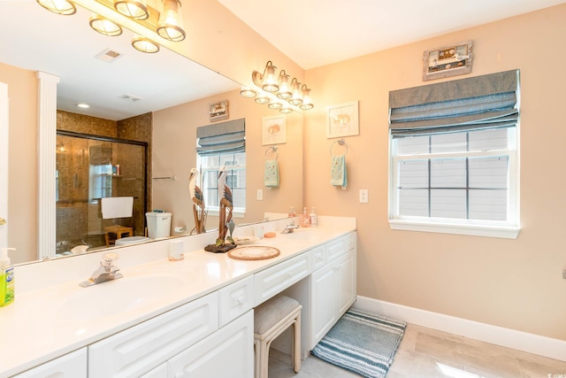 full bathroom featuring a stall shower, double vanity, baseboards, tile patterned flooring, and toilet