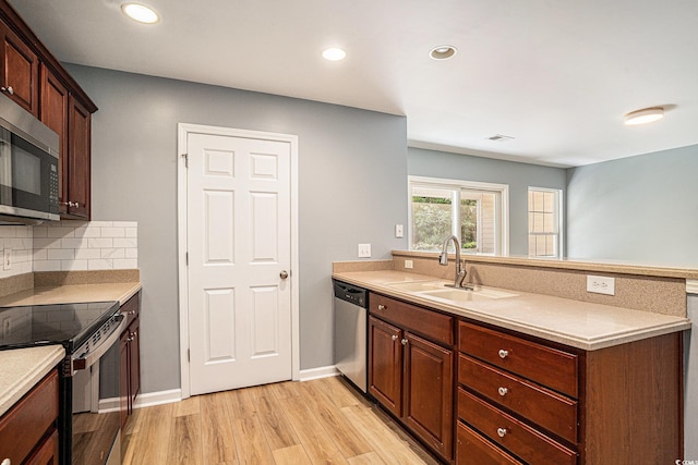 1196 Harvester Cir Unit 1196, Myrtle Beach, SC 29579 - kitchen featuring appliances with stainless steel finishes, a sink, a peninsula, light wood-style floors, and light countertops