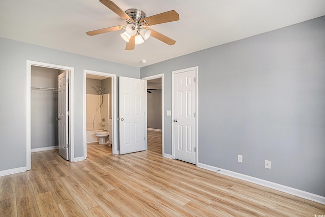 1196 Harvester Cir Unit 1196, Myrtle Beach, SC 29579 - unfurnished bedroom featuring baseboards, light wood finished floors, a closet, a spacious closet, and ensuite bath