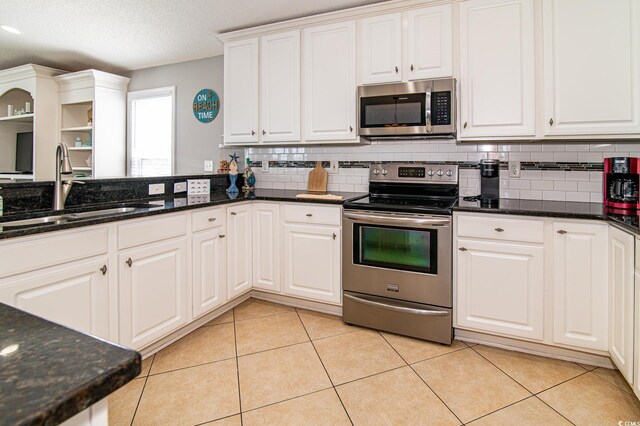 163 Cypress Ave, Murrells Inlet, SC 29576 - kitchen featuring appliances with stainless steel finishes, a sink, tasteful backsplash, white cabinets, and a textured ceiling
