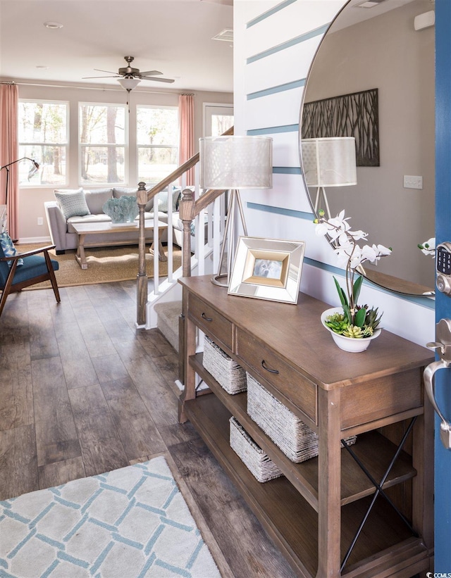 stairs with hardwood / wood-style floors and ceiling fan