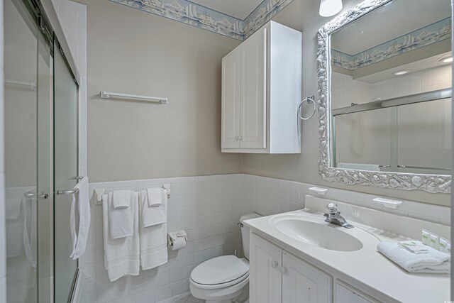 500 23rd Ave S, North Myrtle Beach, SC 29582 - bathroom with a shower stall, vanity, toilet, tile walls, and wainscoting