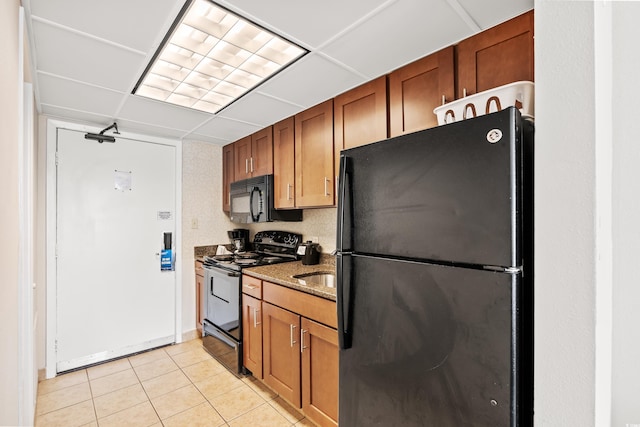 1105 S Ocean Blvd Unit 1048, Myrtle Beach, SC 29577 - kitchen with black appliances, light tile patterned flooring, stone countertops, brown cabinets, and a sink