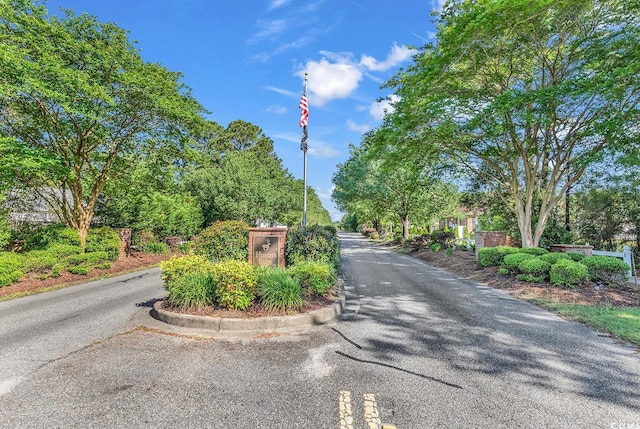 view of asphalt road featuring curbs