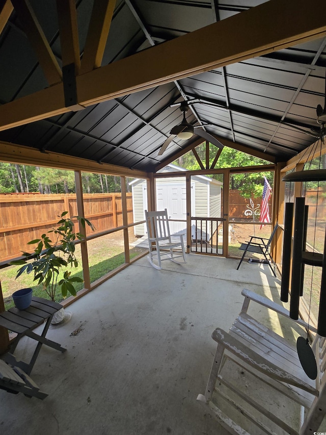 unfurnished sunroom with vaulted ceiling and a ceiling fan