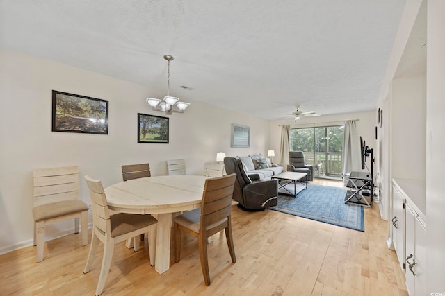 69 Pinehurst Ln Unit 3-F, Pawleys Island, SC 29585 - dining room featuring light wood-style floors, a textured ceiling, a ceiling fan, and a chandelier