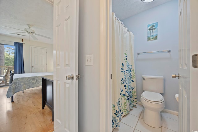 69 Pinehurst Ln Unit 3-F, Pawleys Island, SC 29585 - bathroom featuring toilet, a textured ceiling, a ceiling fan, baseboards, and a shower with shower curtain