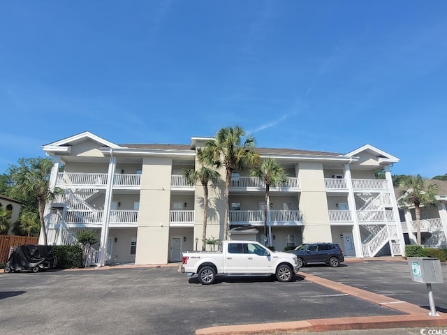 view of apartment building / complex featuring uncovered parking
