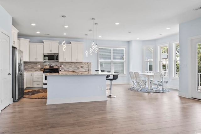400 Elizabeth Dr, Murrells Inlet, SC 29576 - kitchen featuring appliances with stainless steel finishes, backsplash, white cabinets, wood finished floors, and recessed lighting