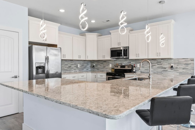 400 Elizabeth Dr, Murrells Inlet, SC 29576 - kitchen featuring stainless steel appliances, a sink, a peninsula, and light stone countertops