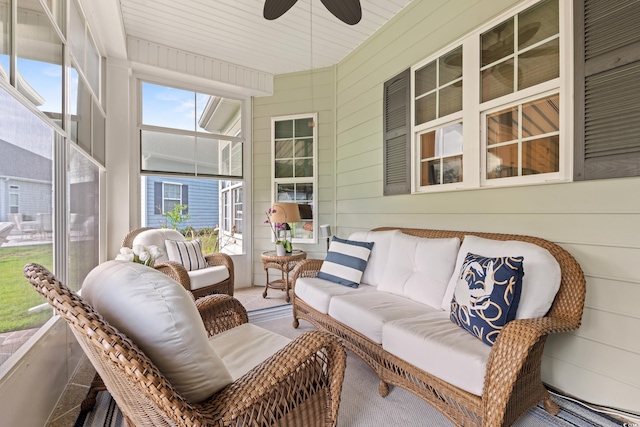sunroom with a ceiling fan, an outdoor living space, and wood walls