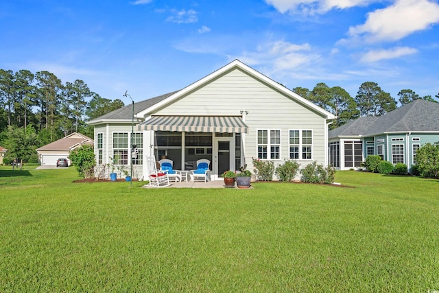 back of property with a yard, a patio area, and a shingled roof