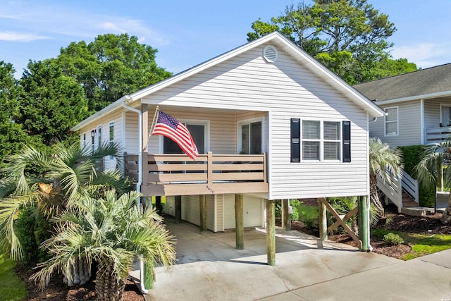 view of front of home with concrete driveway, a balcony, a carport, and an attached garage