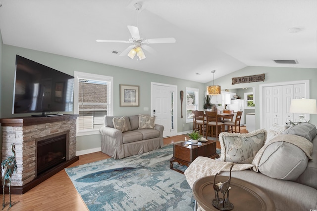 9679 Stillwater Ct, Myrtle Beach, SC 29572 - living room with vaulted ceiling, wood finished floors, ceiling fan, baseboards, and a stone fireplace