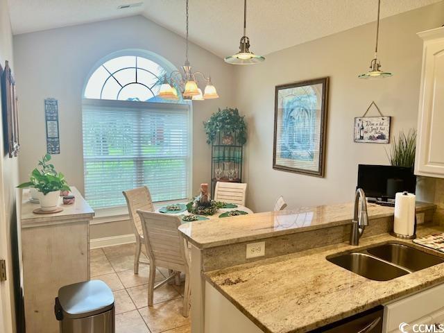 1504 Saint Thomas Cir, Myrtle Beach, SC 29577 - kitchen featuring a sink, vaulted ceiling, pendant lighting, a peninsula, and light tile patterned flooring