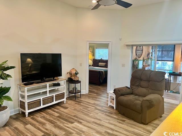 1504 Saint Thomas Cir, Myrtle Beach, SC 29577 - living room featuring ceiling fan, a towering ceiling, wood finished floors, baseboards, and plenty of natural light