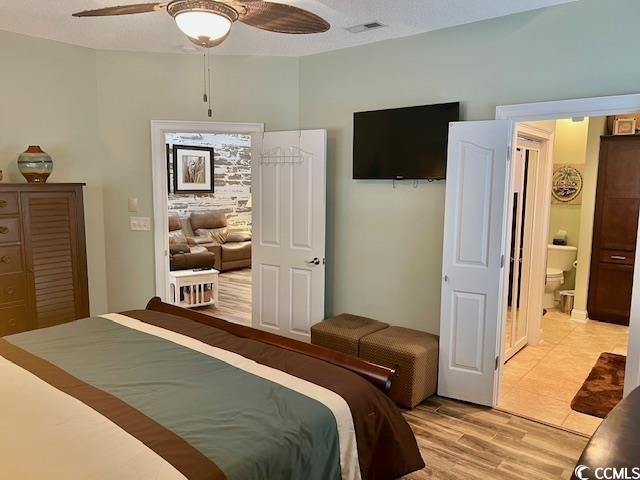 1504 Saint Thomas Cir, Myrtle Beach, SC 29577 - bedroom with light wood-style floors, a ceiling fan, and connected bathroom
