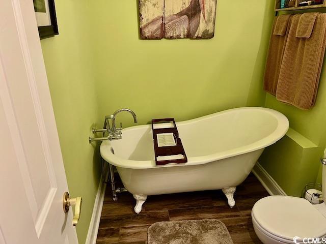 1504 Saint Thomas Cir, Myrtle Beach, SC 29577 - bathroom with wood finished floors, a freestanding tub, toilet, and baseboards