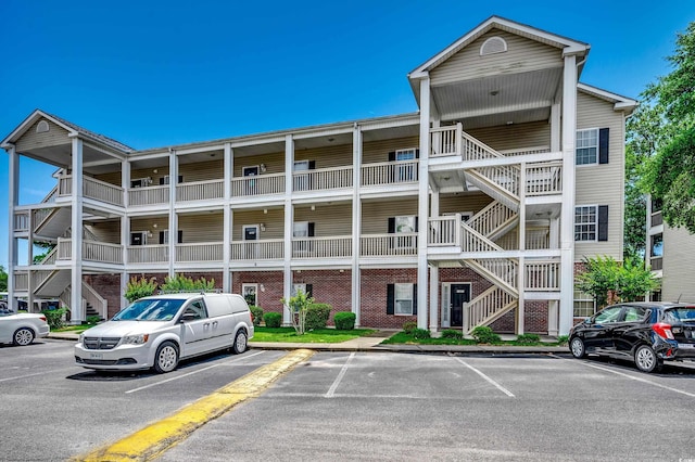 1058 Sea Mountain Hwy Unit 4-203, North Myrtle Beach, SC 29582 - view of building exterior with stairs and uncovered parking