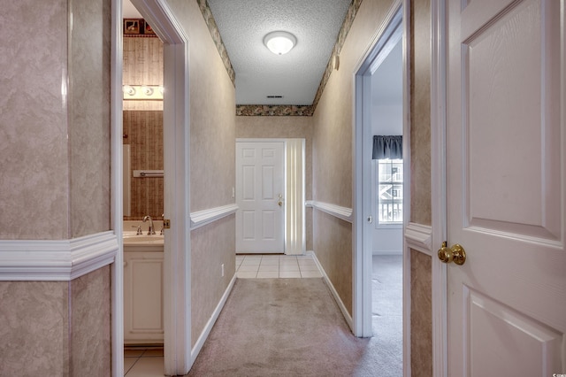 1058 Sea Mountain Hwy Unit 4-203, North Myrtle Beach, SC 29582 - hall featuring a textured ceiling, light colored carpet, a sink, light tile patterned floors, and baseboards