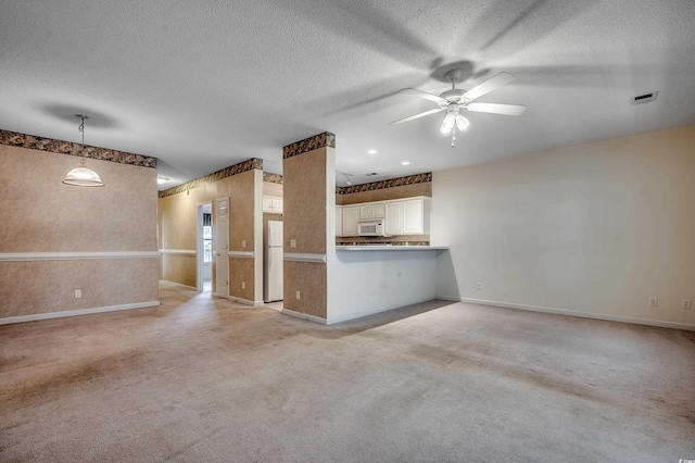 1058 Sea Mountain Hwy Unit 4-203, North Myrtle Beach, SC 29582 - unfurnished living room with baseboards, ceiling fan, a textured ceiling, and light carpet