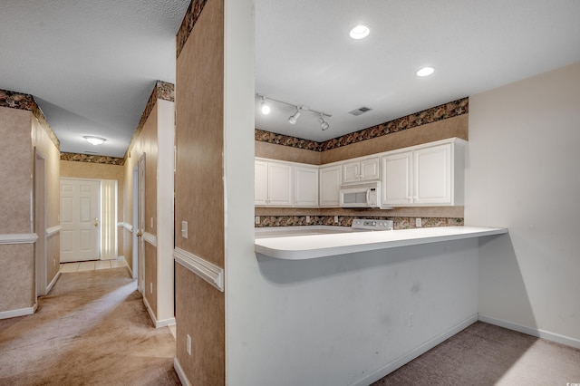 1058 Sea Mountain Hwy Unit 4-203, North Myrtle Beach, SC 29582 - kitchen featuring white microwave, white cabinets, light carpet, baseboards, and light countertops