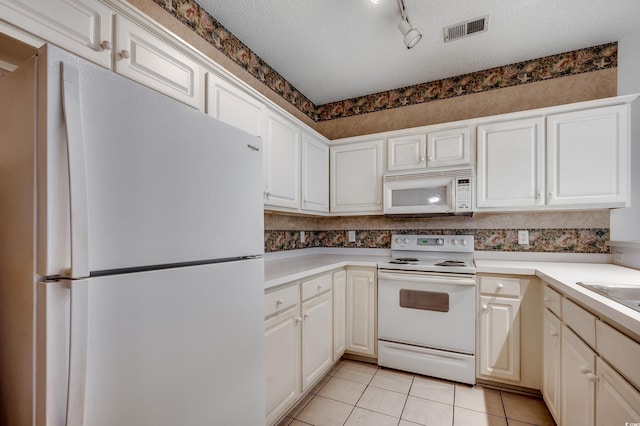 1058 Sea Mountain Hwy Unit 4-203, North Myrtle Beach, SC 29582 - kitchen featuring white appliances, light tile patterned floors, a textured ceiling, track lighting, and white cabinets