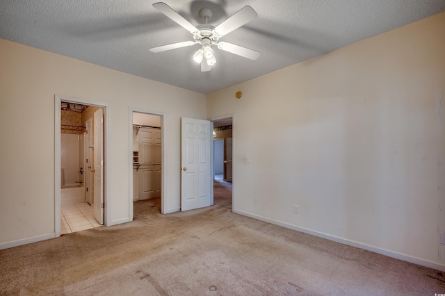 1058 Sea Mountain Hwy Unit 4-203, North Myrtle Beach, SC 29582 - unfurnished bedroom featuring carpet floors, a walk in closet, ensuite bath, baseboards, and a textured ceiling